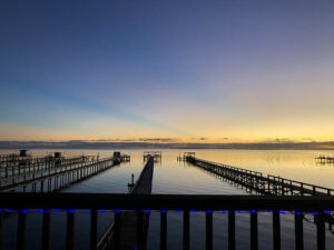 Sunset over calm water with piers.