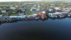 Waterside homes with docks and green landscape.